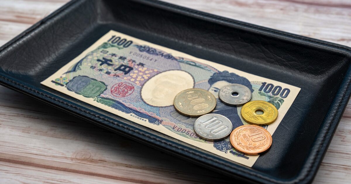レザートレイに置かれた千円札と日本円硬貨の支払いイメージ