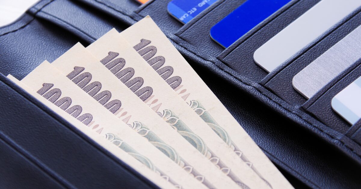 財布のカードポケットに入った紙幣とクレジットカード