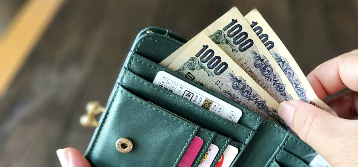 財布から千円札を取り出す手元のクローズアップ