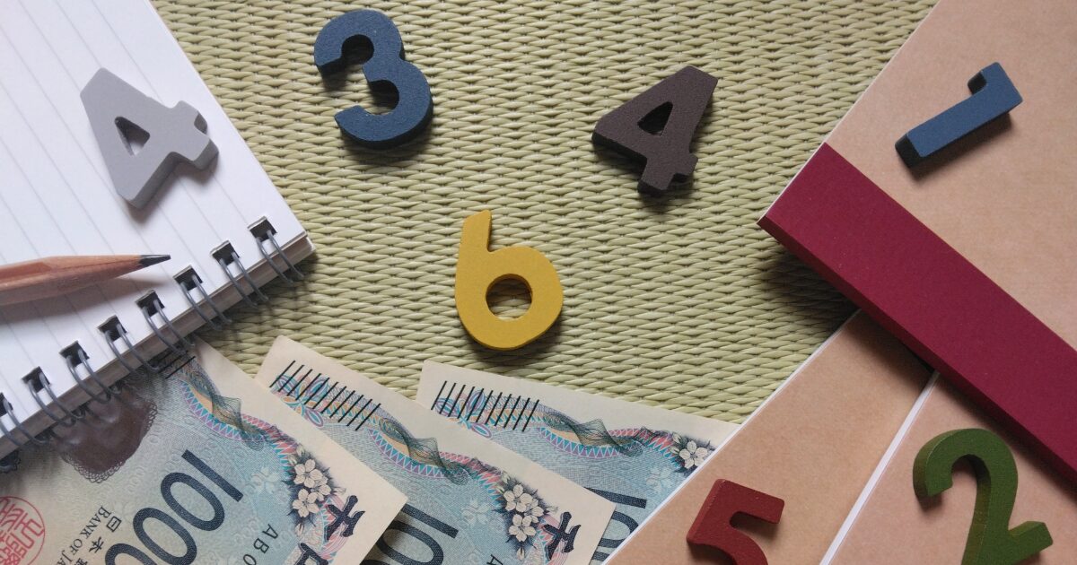 ノートと鉛筆と日本円と数字で表す家計見直しと支出管理のイメージ