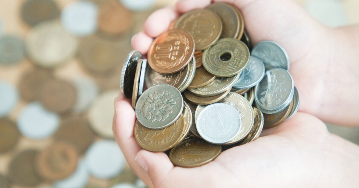 手のひらに載せた日本円硬貨で表す小銭管理と節約のイメージ