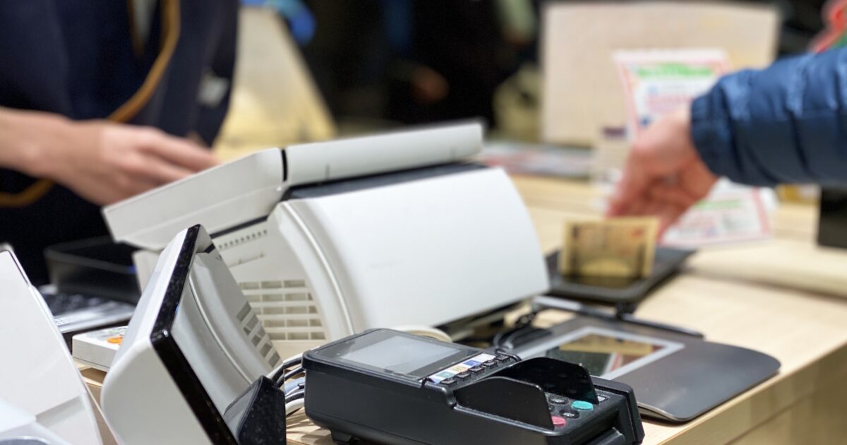 レジで現金支払いをする店頭の様子