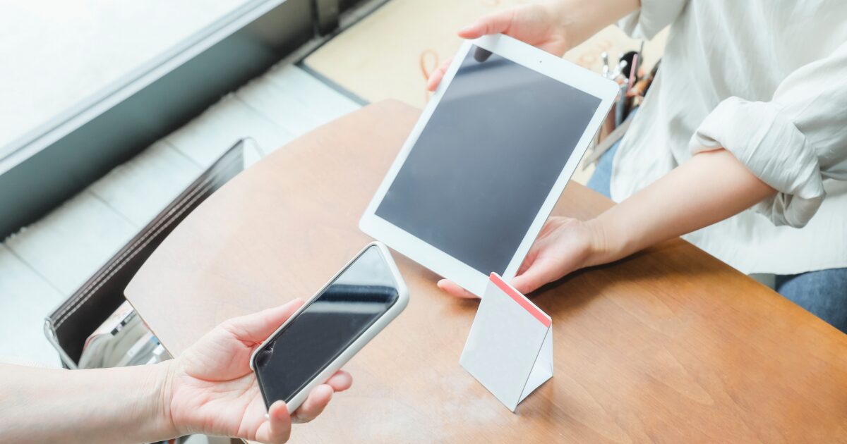 タブレット端末とスマートフォンでキャッシュレス決済を行う手元
